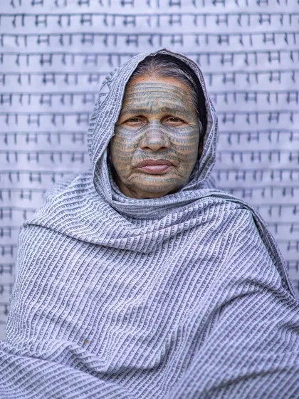 A woman from the Ramnami Samaj, her face tattooed with the name of Lord Ram. This portrait documents a unique and deeply personal expression of faith.