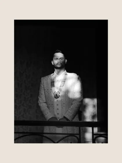 A dramatic black and white portrait of the groom, with light and shadow creating a powerful, artistic effect.