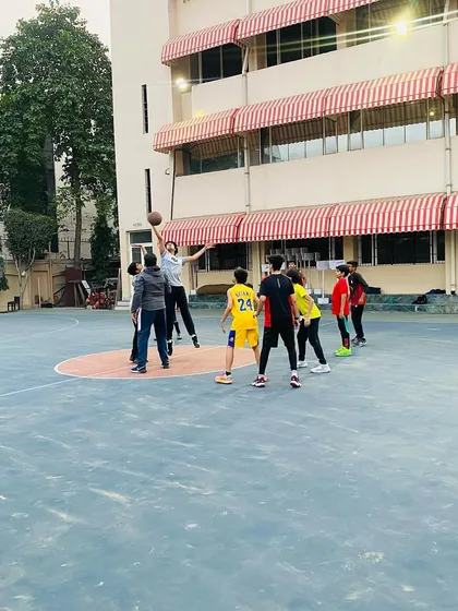 A senior player goes up for a rebound during a friendly match.