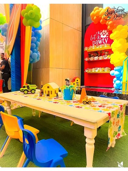 A kids' activity table at the Paw Patrol party, complete with a paw-print table runner and themed toys and props for the children to play with.