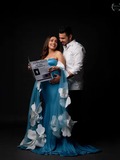 A creative and fun way to announce your pregnancy, with the couple holding a custom "Baby Times" newspaper.