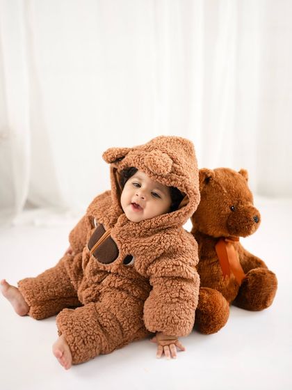 A happy little bear. This seven-month-old is all smiles in his adorable costume, sitting up proudly for his milestone portrait.