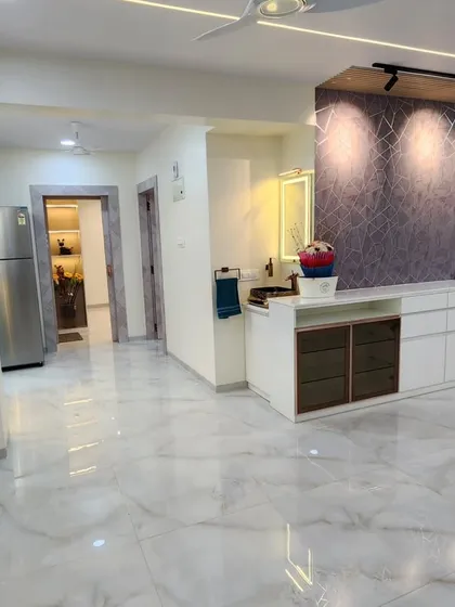 A wide shot of the living and dining area, showing the seamless marble flooring and the well-defined functional zones.