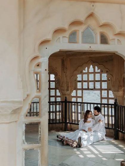 A fairytale moment captured in a sunlit palace corridor. The intricate latticework and repeating arches create a beautiful, light-filled setting for this romantic couple portrait.