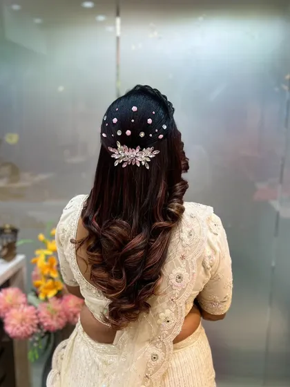 A classic half-up style with beautiful curls, elevated with a sparkling crystal hairpiece.
