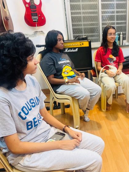 Students listening intently during a practice session for their event performance. Discipline and focus are key skills learned through these experiences.