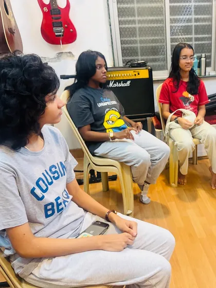 Students listening intently during a practice session for their event performance. Discipline and focus are key skills learned through these experiences.