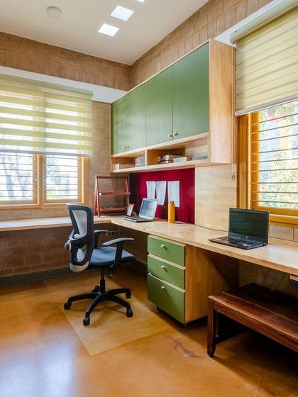 The L-shaped study table provides ample workspace, surrounded by the warmth of earth blocks.