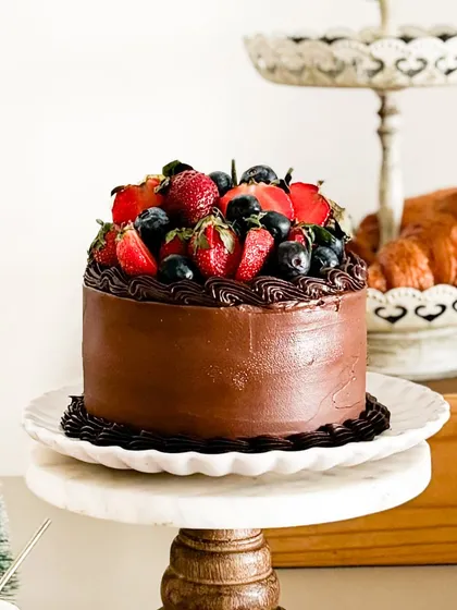 This is my "Strawberry Symphony" cake. It's a beautiful blend of vanilla sponge, fresh strawberries, and dark chocolate, topped with a medley of fresh berries.