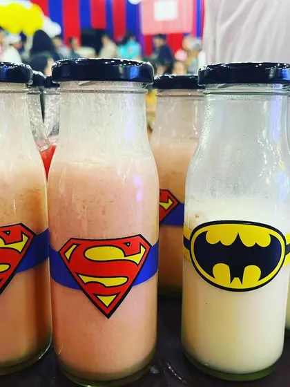 Even the drinks were on theme! We served milkshakes in these fun superhero-themed bottles, featuring logos like Superman, Batman, and Spiderman, adding another layer of detail to the kids' party.