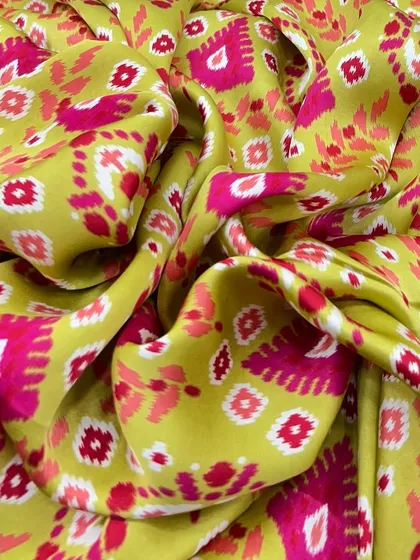 A bright and cheerful ikat-style print on our lime green modal satin. This fabric is perfect for creating outfits that are full of personality and style.