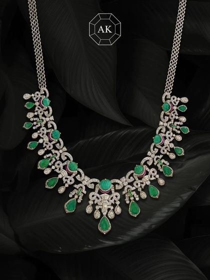 This striking necklace blends two shades of natural Zambian emeralds with diamonds and a hint of rubies in 18K gold, perfect for carrying culture with style.
