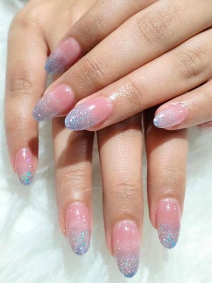 A cool and frosty look with a sheer pink base that fades into a beautiful blue and silver glitter ombré at the tips.