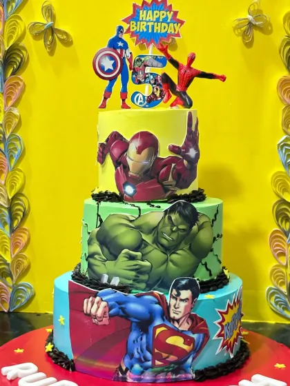 A superhero mashup of epic proportions. This four-tiered cake features Superman, Hulk, Iron Man, and Captain America, creating a powerful centerpiece for a 5th birthday.