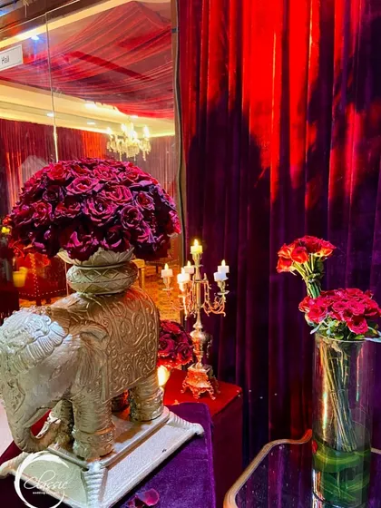 Another view of the golden elephant decor piece, showing how it reflects the candlelight and adds a touch of Indian royalty to the rich, red-themed setting.