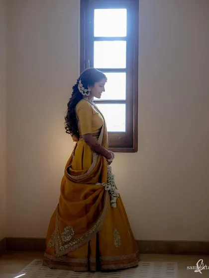 A simple, beautiful portrait of Deeksha by a window just before her haldi. The natural light and her elegant pose create a timeless and serene image.