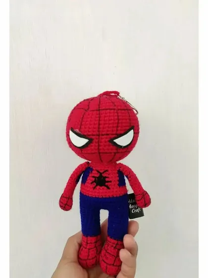 A full-length view of the handmade Spider-Man crochet doll. This angle clearly shows the detailed stitch work on his mask and body, and the metal ring at the top for attaching it to keys.