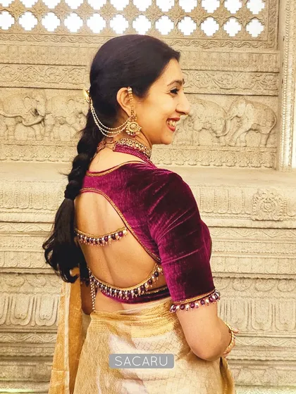 Our client Krupa, the picture of poise in a rich magenta velvet blouse. The design features an elegant open back with delicate bead detailing along the straps and sleeves.