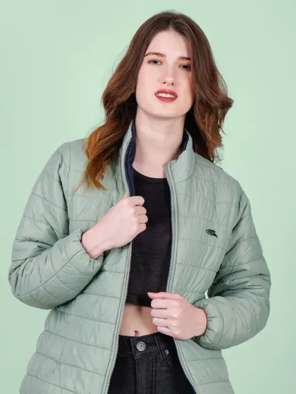 A model wearing a light green puffer jacket against a complementary pastel green background, creating a visually pleasing and cohesive look.