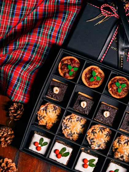 Our Christmas taster box offers a delightful variety of festive sweets. It includes traditional mince pies, rich chocolate hazelnut bites, and iced fruitcake squares, all beautifully arranged for gifting.