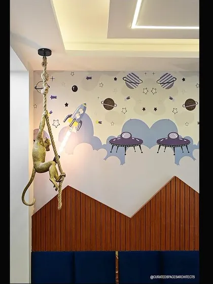 A detail of the custom-painted wall mural in the kids' bedroom. The whimsical space theme, complete with planets and UFOs, is designed to inspire creativity and fun.