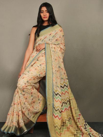 A model seated elegantly in a floral print saree, demonstrating how I capture the drape and texture of the fabric for saree catalogs.
