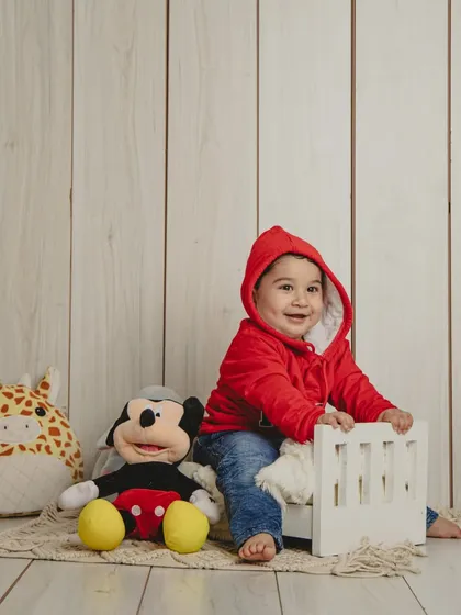 A happy baby boy in a cozy setup with his favorite stuffed toys. These simple sessions are perfect for capturing your child at any stage.
