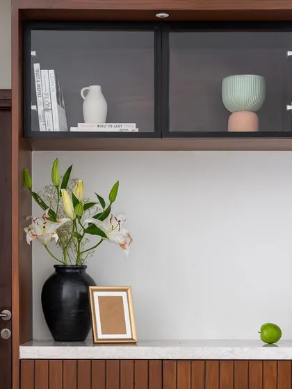 A closer look at the integrated crockery and puja unit, showing the glass-fronted display shelves and the dedicated space for deities.