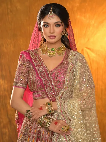 A blushing beauty in pink. This full bridal look features a stunning pink lehenga, complementary makeup, and exquisite jewellery.