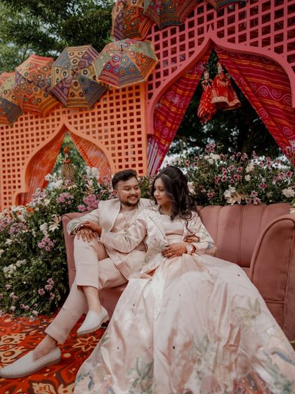 A relaxed portrait of the couple seated together at their Rajasthani-themed Sangeet.
