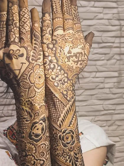 A heart with the couple's initials is a popular and romantic choice for personalizing your bridal mehendi.