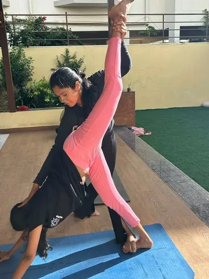 Helping a young dancer achieve a standing split. My workshops for performers focus on targeted stretches and strengthening exercises to enhance their flexibility and prevent injuries.
