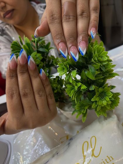 A modern V-shaped French tip using a bold blue color. This is a great way to add a pop of color while keeping the classic French feel.