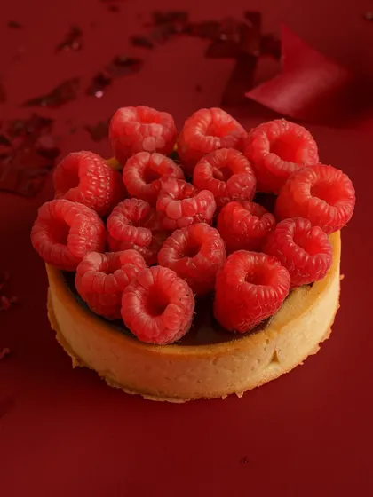 Sometimes, simple is most powerful. This shot uses a bold, monochromatic background to make the vibrant raspberries and the perfect tart shell pop. This artistic approach is great for high end bakeries and brands wanting a sophisticated, editorial look.