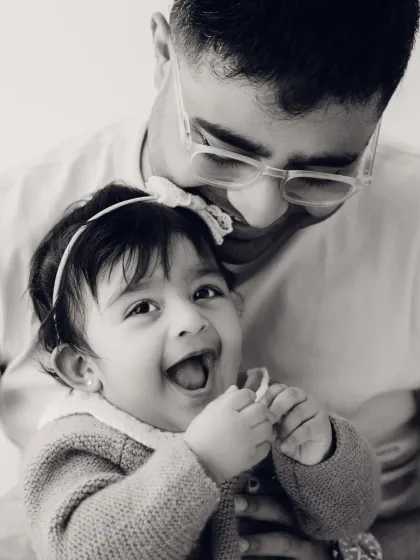 A father and daughter share a laugh in this sweet black and white close-up. The focus is entirely on their happy connection.