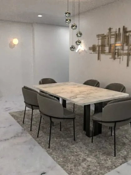 A concept for a modern dining area with a marble-topped table and striking metallic wall art.