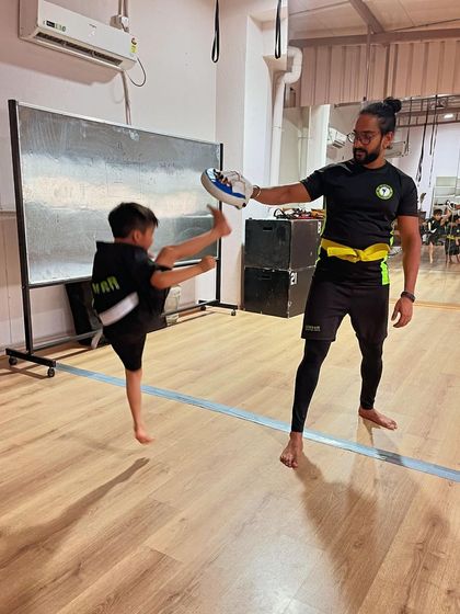 Flying high. This young student shows incredible form and height in his kick, a result of consistent practice and dedication.