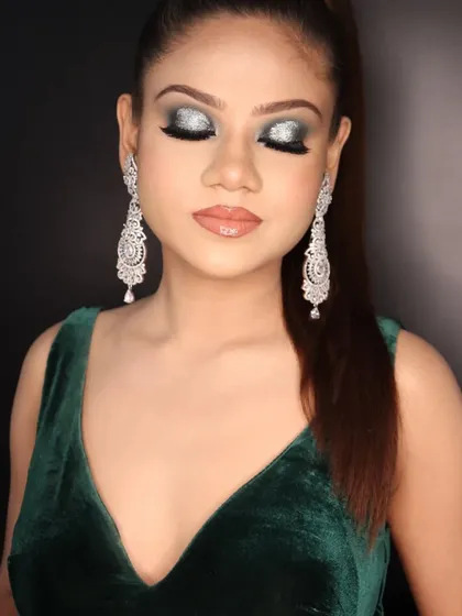 Eyes closed to showcase the beautiful glitter and blending of the green and silver smokey eye makeup.