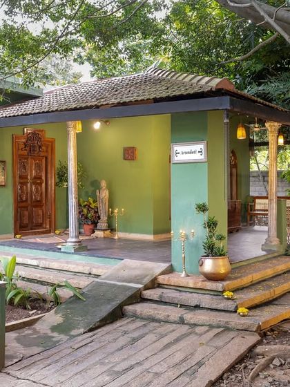 The vibrant green exterior of one of our heritage suites, with traditional wooden pillars and a welcoming entrance.