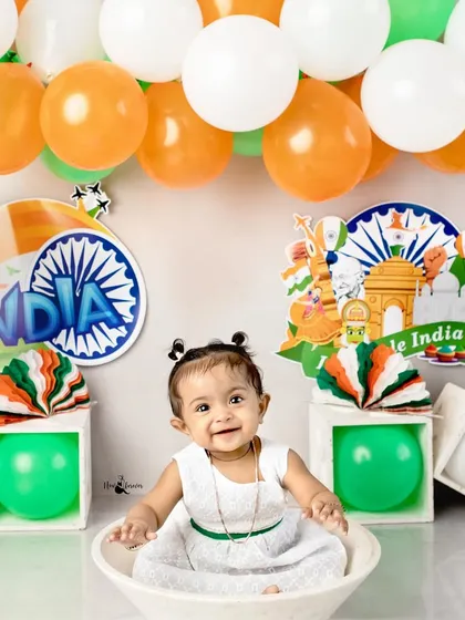 A smile for the nation. This adorable baby celebrates in our Independence Day themed setup, complete with tricolor balloons and patriotic decorations.
