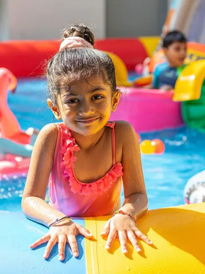 This sweet girl is taking a little break from swimming to smile for the camera. Our pool parties are full of these happy, photogenic moments.
