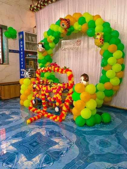 The jungle naming ceremony setup without party lights, showing the bright colors of the balloons and flowers.