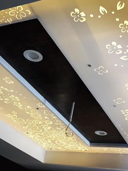 A beautiful false ceiling design where a floral pattern is cut into a Corian panel and backlit. This creates a soft, diffused light and an enchanting, decorative effect.