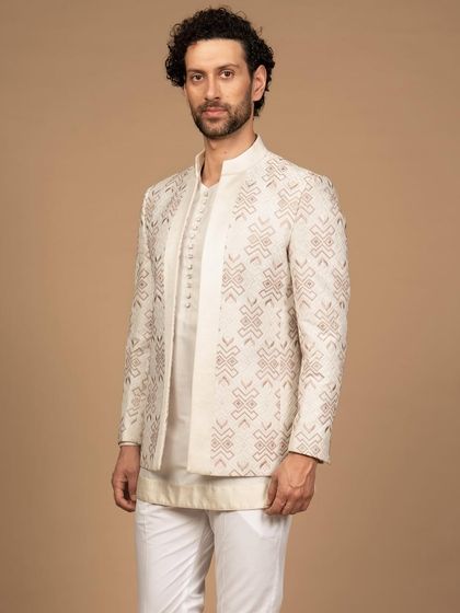 This pastel-shade embroidered bandhgala-style jacket offers a unique silhouette. The intricate geometric pattern provides a modern contrast to the soft, traditional color, creating a look of sophisticated elegance.