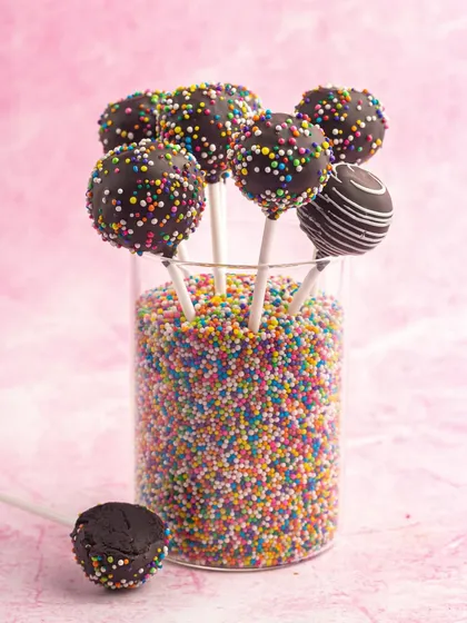 A fun display of my chocolate sprinkle cake pops. They are perfect for birthday parties and celebrations, adding a pop of color and sweetness to any dessert table.