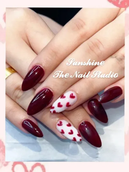 A perfect Valentine's Day look. This set combines deep maroon with white accent nails covered in tiny red hearts.