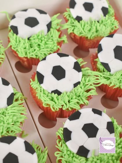 A closer look at the football cupcakes, perfect for party favors or as part of a larger dessert spread. The piped grass adds a fun texture.
