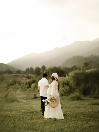 A journey into parenthood, set against a breathtaking mountain landscape. The couple walks hand-in-hand through a green valley, symbolizing their adventure together.