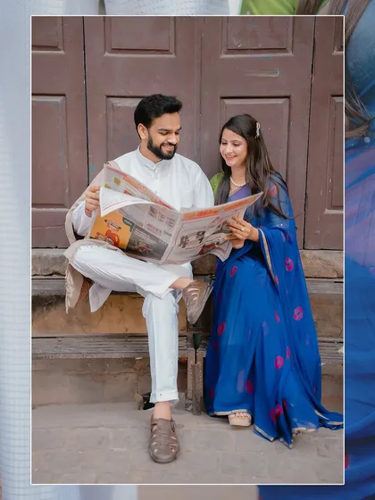 An artistic shot of the couple reading a newspaper together, framed to create a sense of intimacy and shared daily life.