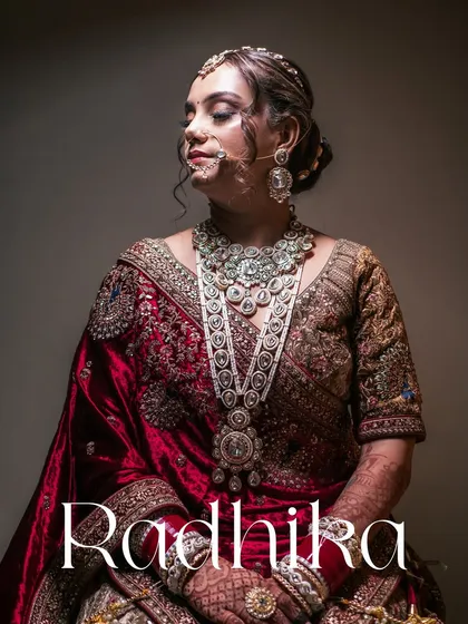 A quiet moment of reflection for the bride, Radhika, in her stunning North Indian bridal attire. We use dramatic lighting to highlight the intricate details of her jewelry and the rich velvet of her lehenga, creating a timeless and elegant bridal portrait.
